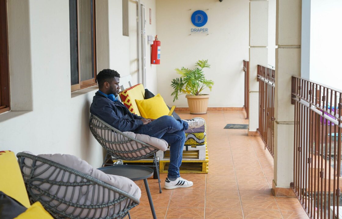 Image of man sitting at BongoHive wit Draper Startup House logo on the background